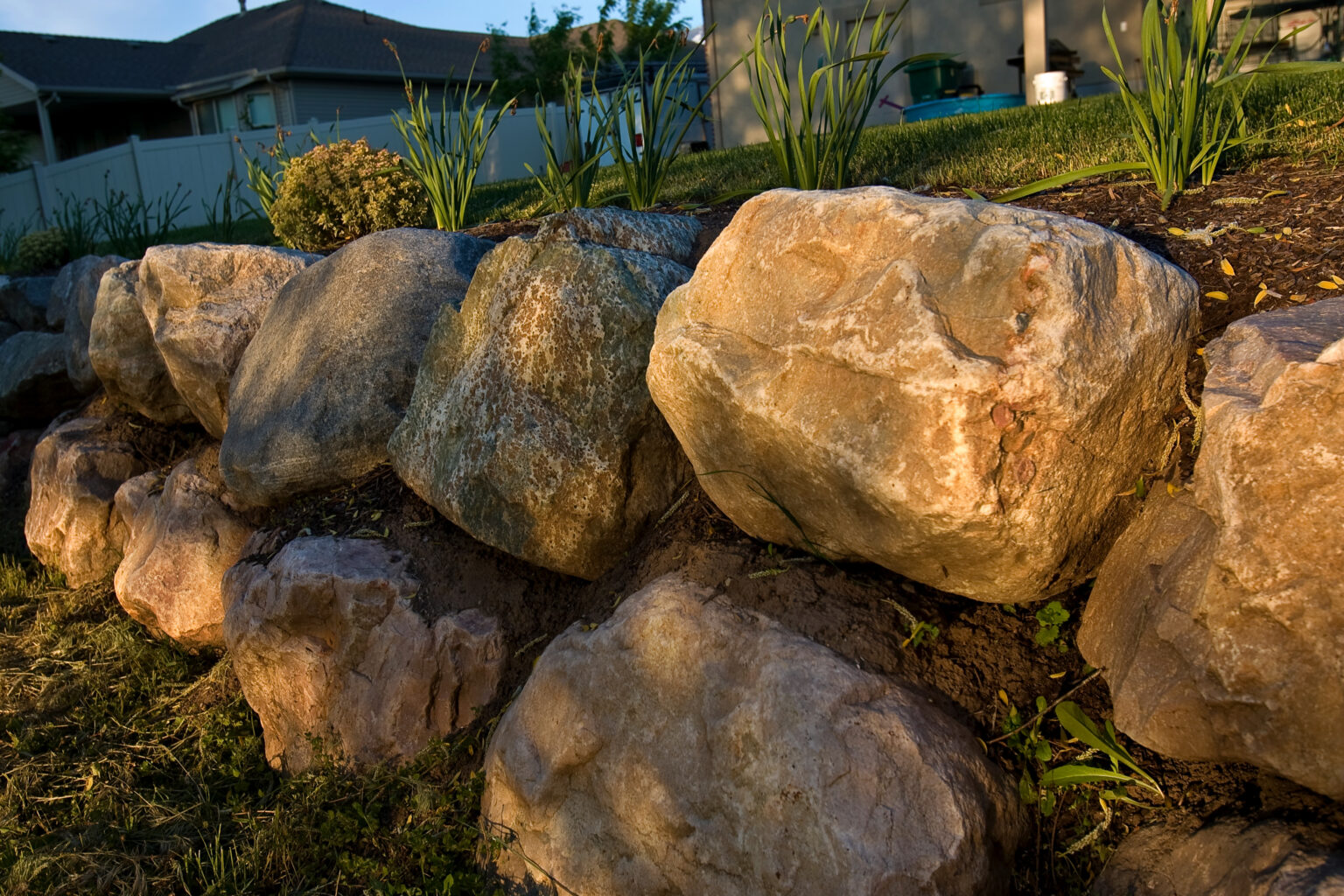 A rock wall retains a backyard.